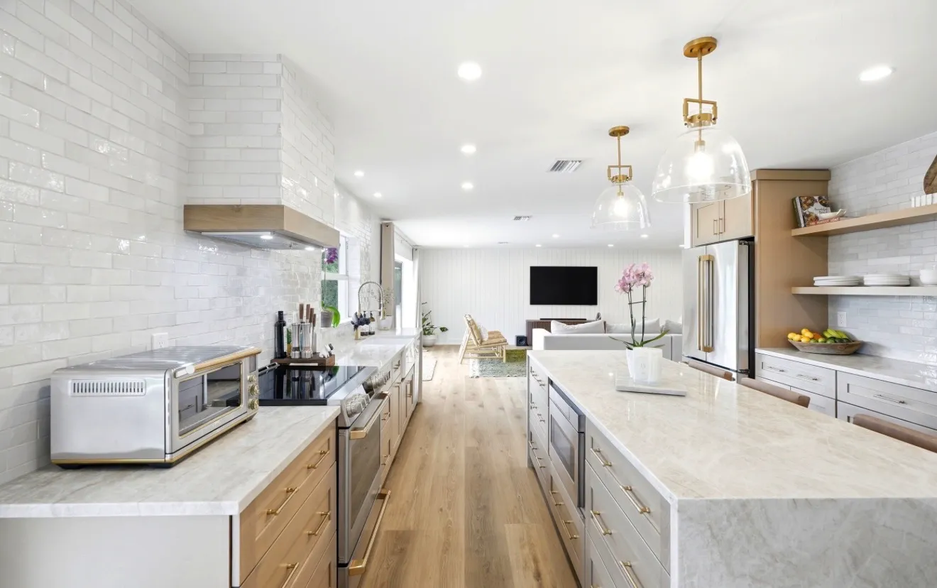 The same white oak kitchen photographed toward the living space
