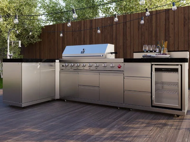 Stainless outdoor kitchen run turning a corner, with a built-in grill, undercounter refrigeration, dark stone counters and closed storage below