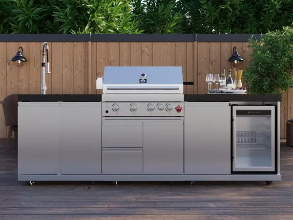 Stainless outdoor kitchen with a built-in grill, sink, undercounter beverage refrigerator and drawer storage along a covered deck