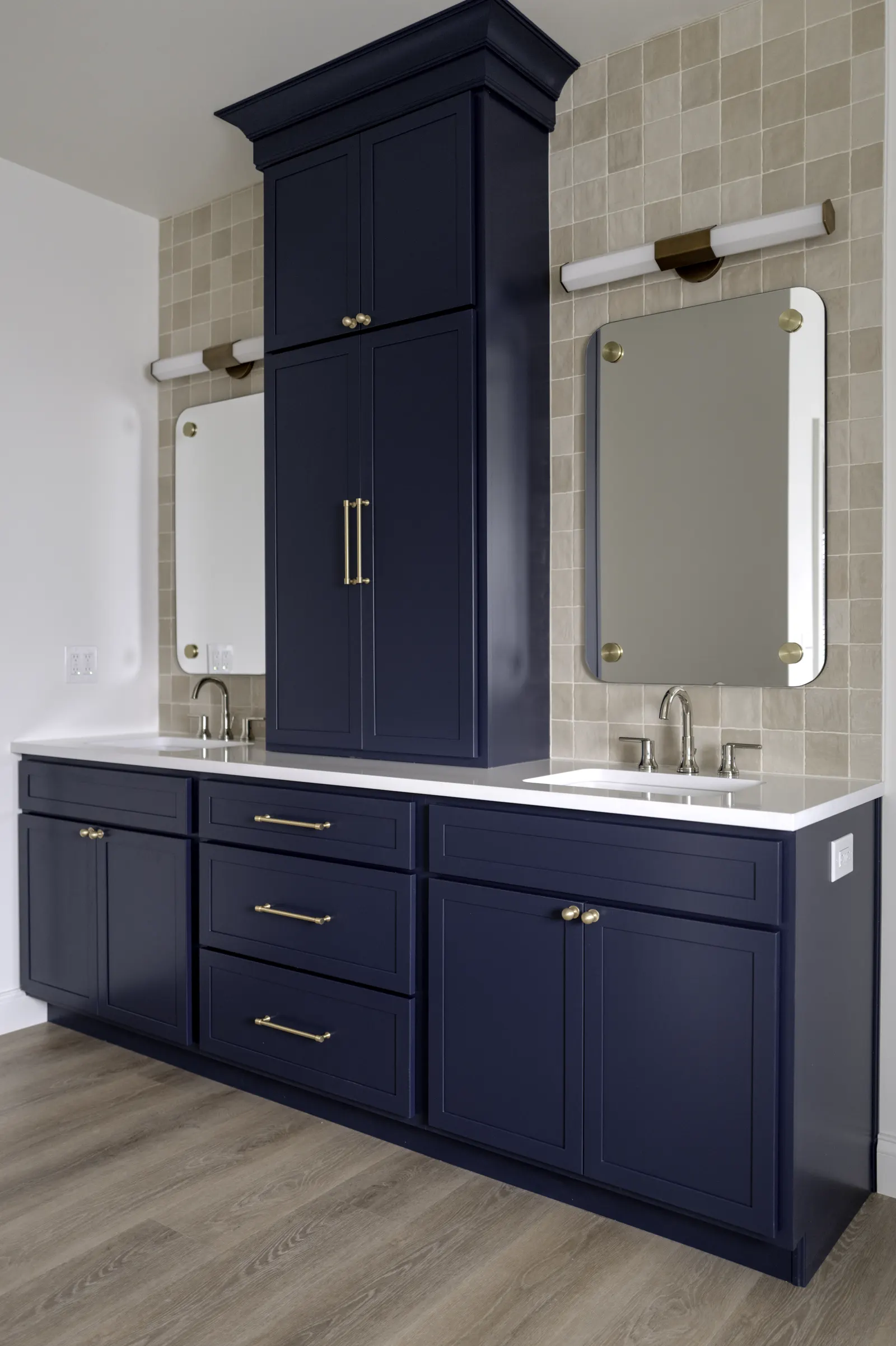 Navy double vanity with a bridge cabinet between the basins