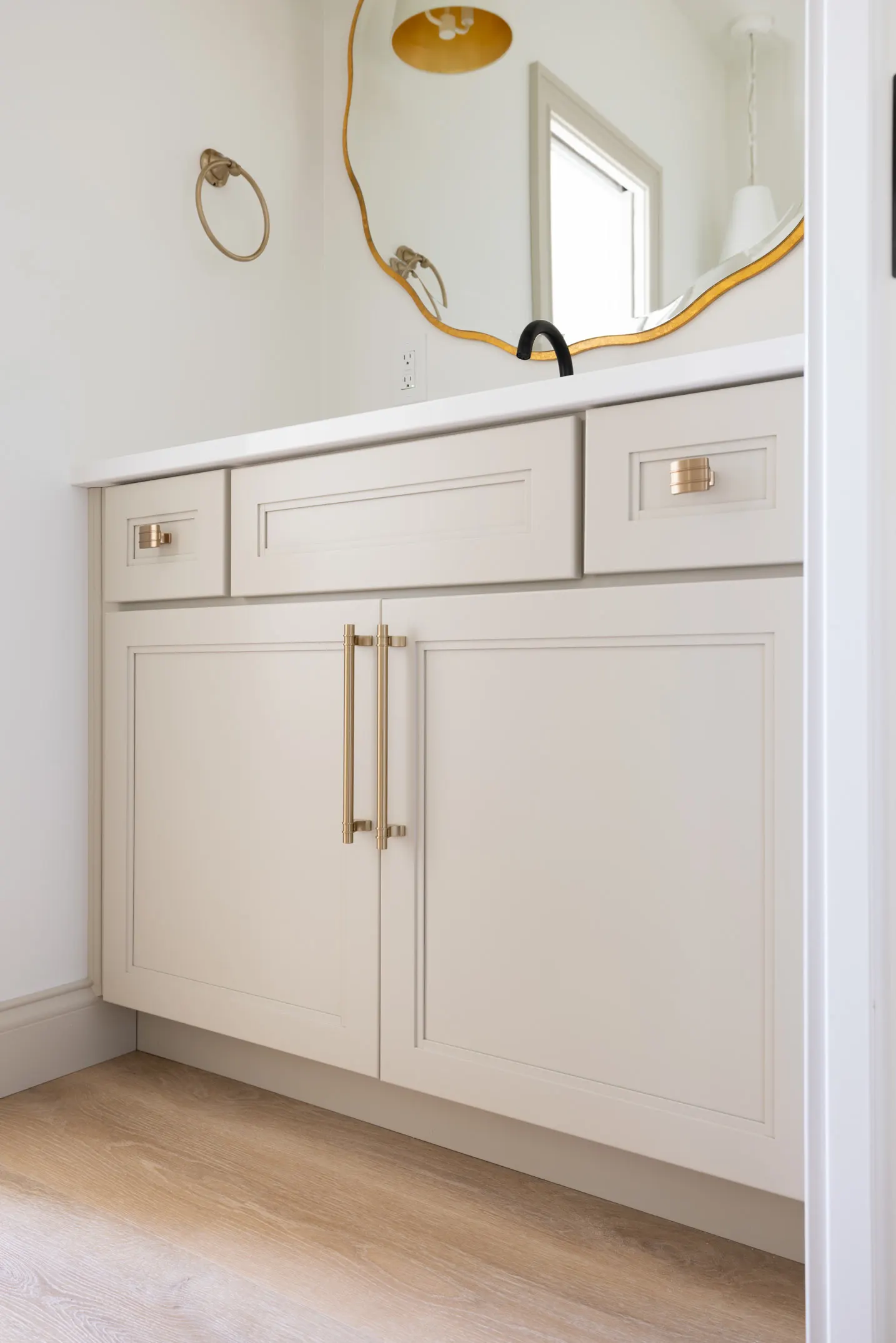 Cream bathroom cabinetry with brass fittings