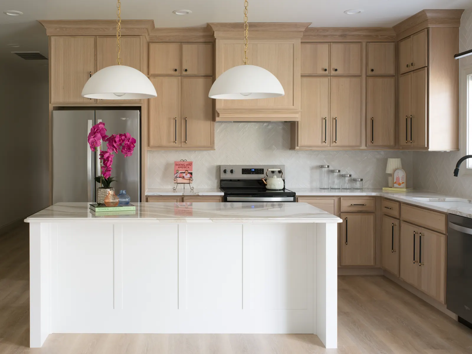 Light oak cabinetry with a white island in a bright open kitchen